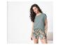 Femme en t-shirt vert et short à motifs imprimé tropical.