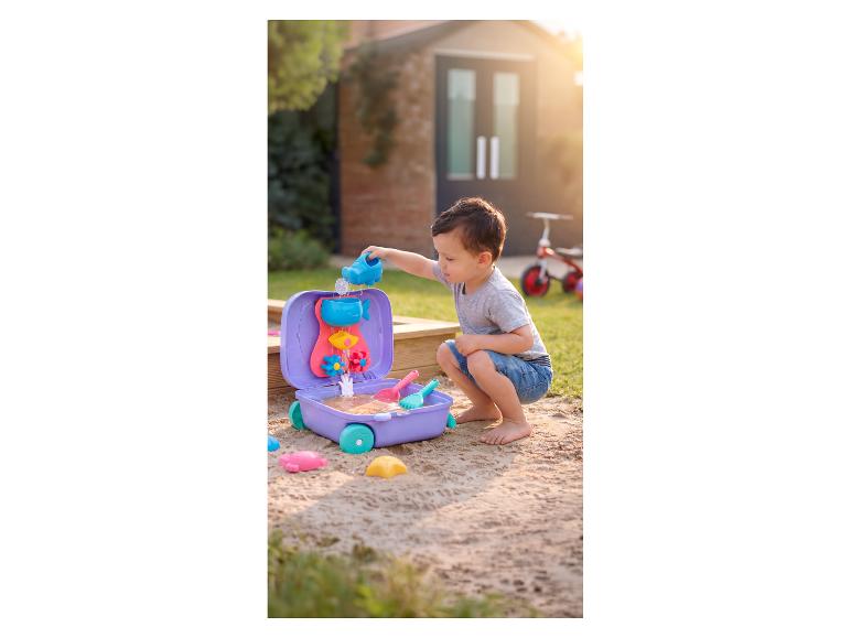 Enfant jouant avec une table de jeu d'eau et de sable dans un bac à sable.