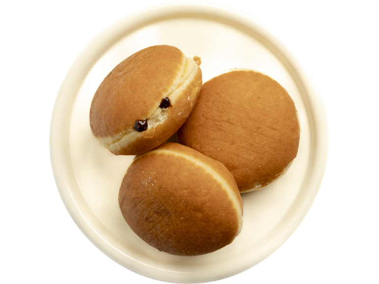 Trois beignets fourrés sur une assiette claire.