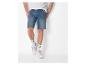 Short en jean bleu et baskets blanches.