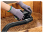 Une main tenant une ponceuse électrique avec aspirateur.