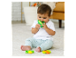 Bébé joue avec des jouets sensoriels en forme de légumes.