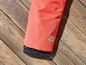 Une jambe de pantalon rose avec un ourlet élastique et des détails réfléchissants.
