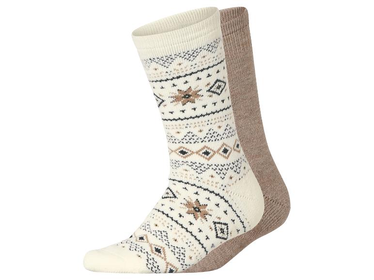 Une paire de chaussettes douillettes et à motifs, crème et marron.
