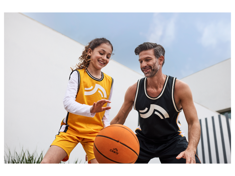 Père et fille jouant au basket-ball avec des ballons Crivit.