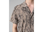 Une chemise beige à manches courtes avec un motif abstrait.