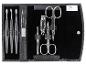 Une trousse en cuir noir avec des outils de manucure, comprenant deux ciseaux, un coupe-ongles et une lime.
