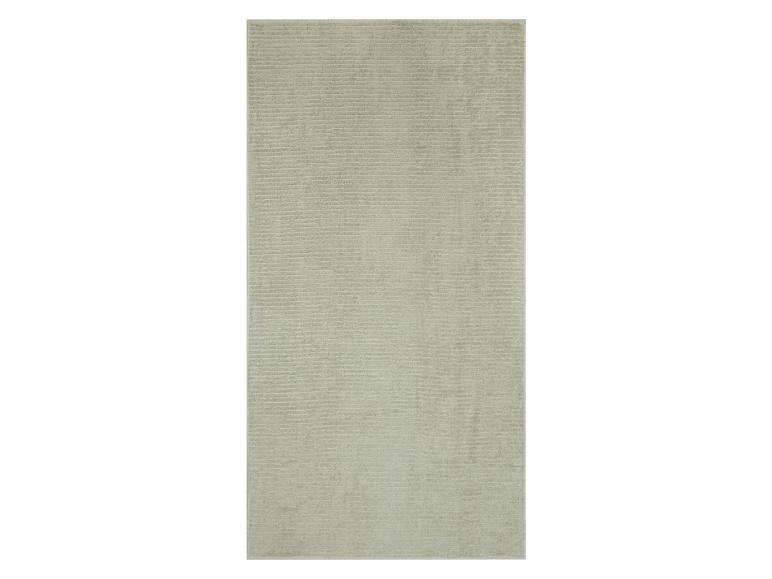 Serviette de bain beige texturée.
