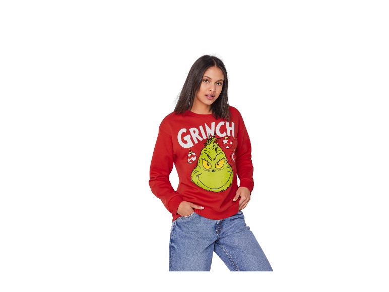 Femme en pull Grinch rouge et jean bleu