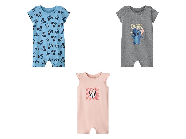 Trois barboteuses pour bébé : une bleue avec Mickey Mouse, une grise avec Stitch et une rose avec Minnie Mouse.
