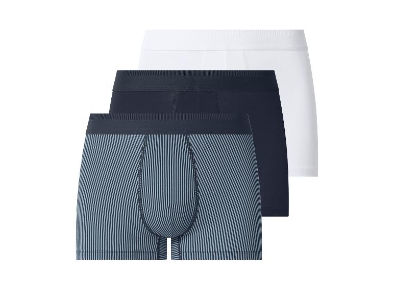 Trois boxers pour hommes : un blanc, un bleu foncé et un rayé.