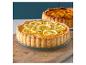 Une tarte au citron et pistache sur une planche en bois.