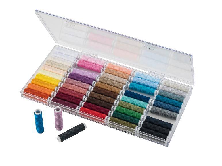 Boîte transparente avec des bobines de fil de plusieurs couleurs.