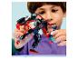 Un enfant joue avec un robot jouet noir et rouge et une petite figurine bleue.