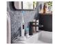 Une brosse à dents électrique Oral-B sur son socle de charge dans une salle de bain.