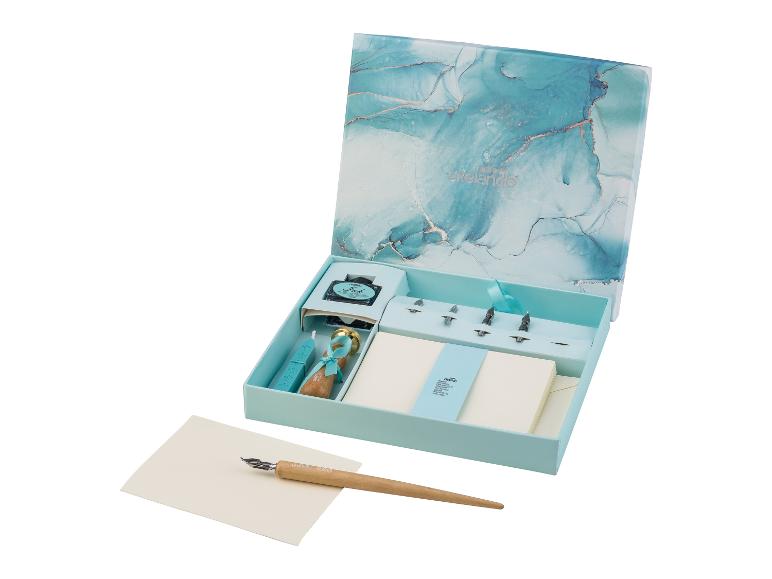 Ensemble de calligraphie avec plume, encre, sceau de cire et papier, dans une boîte marbrée.