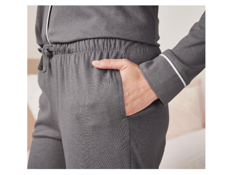 Gros plan sur un pantalon de pyjama gris avec une bordure blanche.