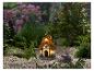 Une maison de conte de fées illuminée avec un toit de chaume dans un jardin avec du gravier
