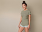 Une femme porte un t-shirt vert et un short rayé.