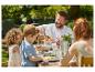 Famille partageant des pâtes et un repas en plein air.