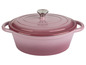 Une cocotte en fonte rose avec un couvercle.