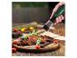 Moulin à épices électrique au-dessus de viande grillée avec légumes sur une planche en bois.