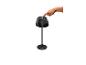 Une main appuie sur le bouton d'alimentation d'une lampe de table noire à abat-jour plissé.