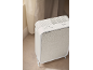 Purificateur d'air blanc avec panneau frontal en tissu gris clair et boutons de commande.