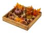 Plateau en bois avec une petite citrouille, des pommes de pin, des feuilles d'érable et un verre.