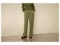 Pantalon vert avec des chaussures plates.