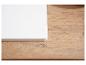 Coin d'une planche à découper blanche sur une surface en bois