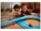 Des enfants jouent avec une piste de course Mario Kart.