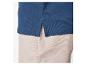 Polo bleu marine et pantalon beige clair.