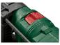 Gros plan d'un outil électrique vert et noir avec un bouton rouge et un guide de mesure.