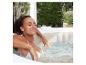 Femme se relaxant dans un jacuzzi bouillonnant en extérieur.