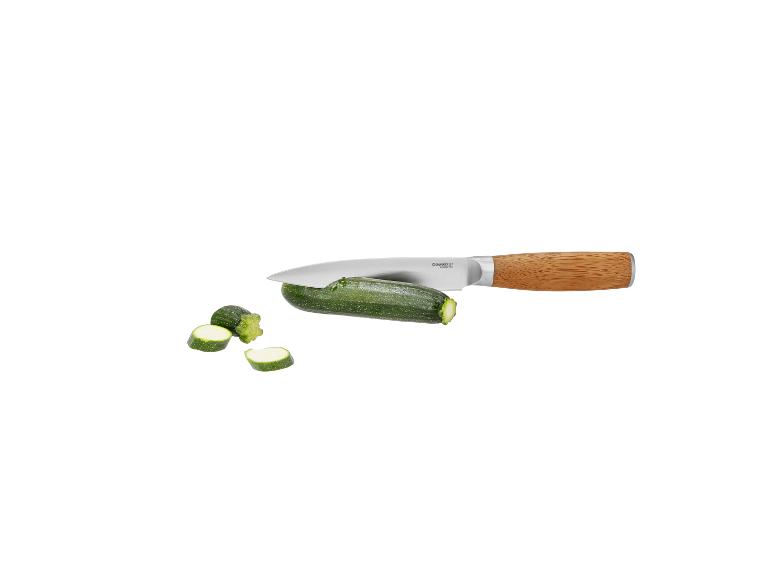 Couteau de cuisine avec manche en bois coupant une courgette en tranches.