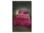 Parure de lit rose et fuchsia à motifs géométriques sur un lit avec une lampe de chevet.