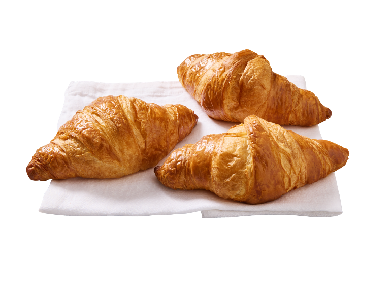 Trois croissants dorés sur un linge blanc.