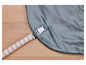 Un tissu gris avec un ruban rayé blanc et une boucle blanche.