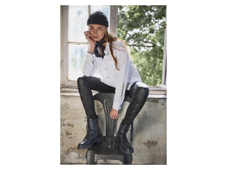 Femme en chemise blanche, leggings effet peau de serpent et bottes militaires.