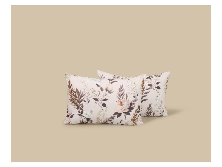 Deux oreillers à motif floral dans des tons beiges et marrons.