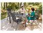 Table et chaises de jardin pliantes grises ; repas en extérieur.