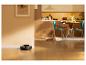 Aspirateur robot sur un parquet dans une cuisine-salle à manger avec un chat.