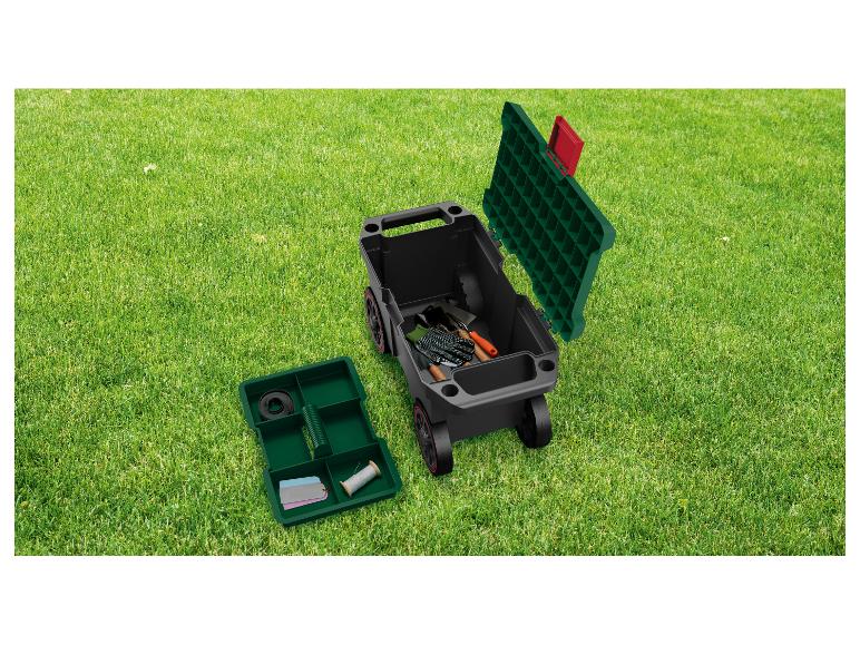 Chariot de jardin avec outils et boîte de rangement sur herbe verte.