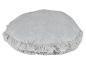Un coussin rond gris avec un bord en fourrure.
