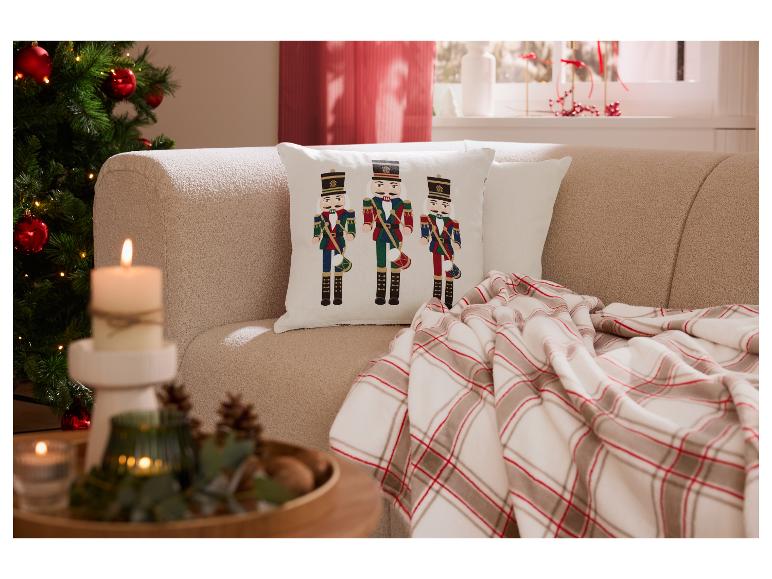 Salon de Noël douillet avec canapé, coussin casse-noisette et plaid.