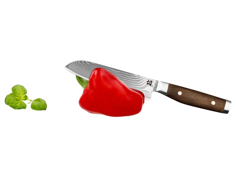 Poivron rouge et couteau à manche en bois, à côté de feuilles de basilic.