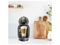 Une machine à café Krups Nespresso noire avec une tasse de latte macchiato