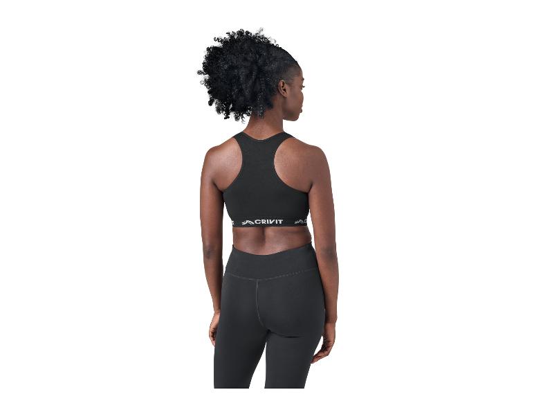 Femme de dos en brassière de sport noire et legging, regardant sur le côté.