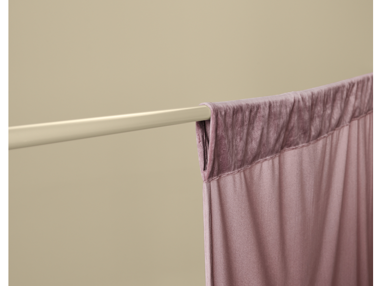 Gros plan d'un rideau mauve sur une tringle claire.